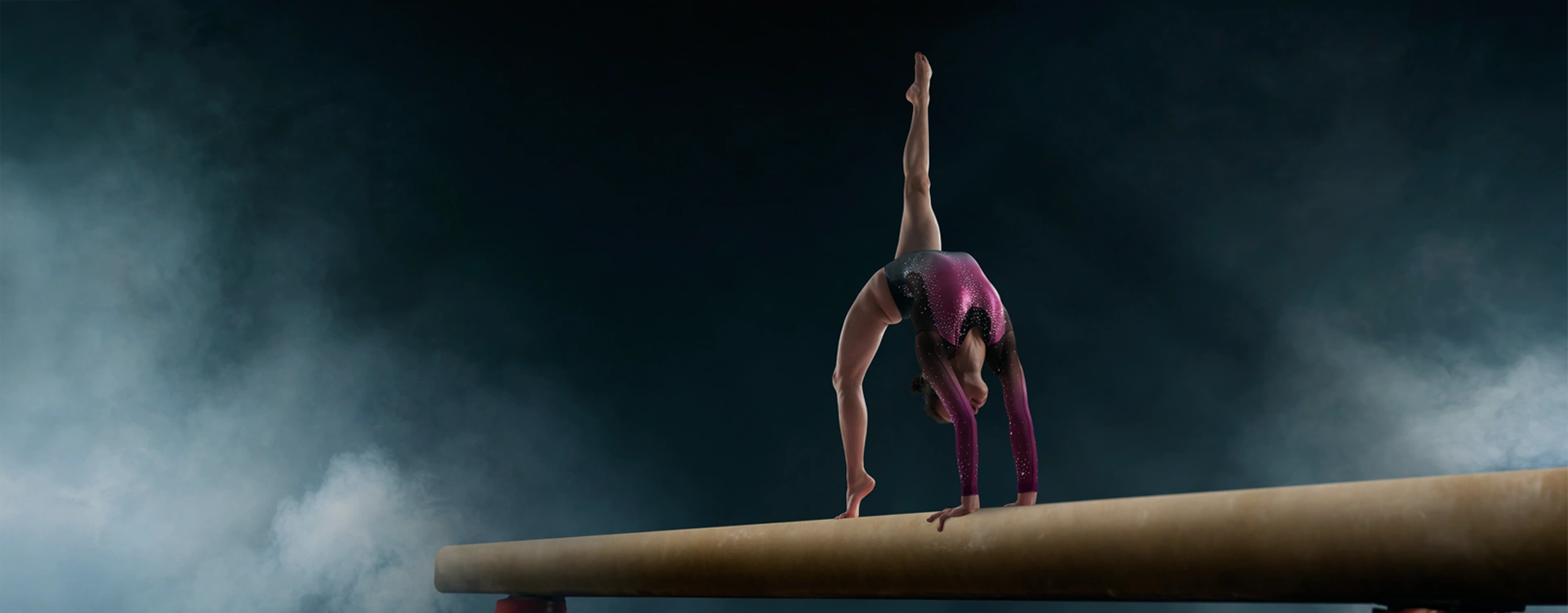 Woman doing gymnastics, in a spectacular pose on the bar